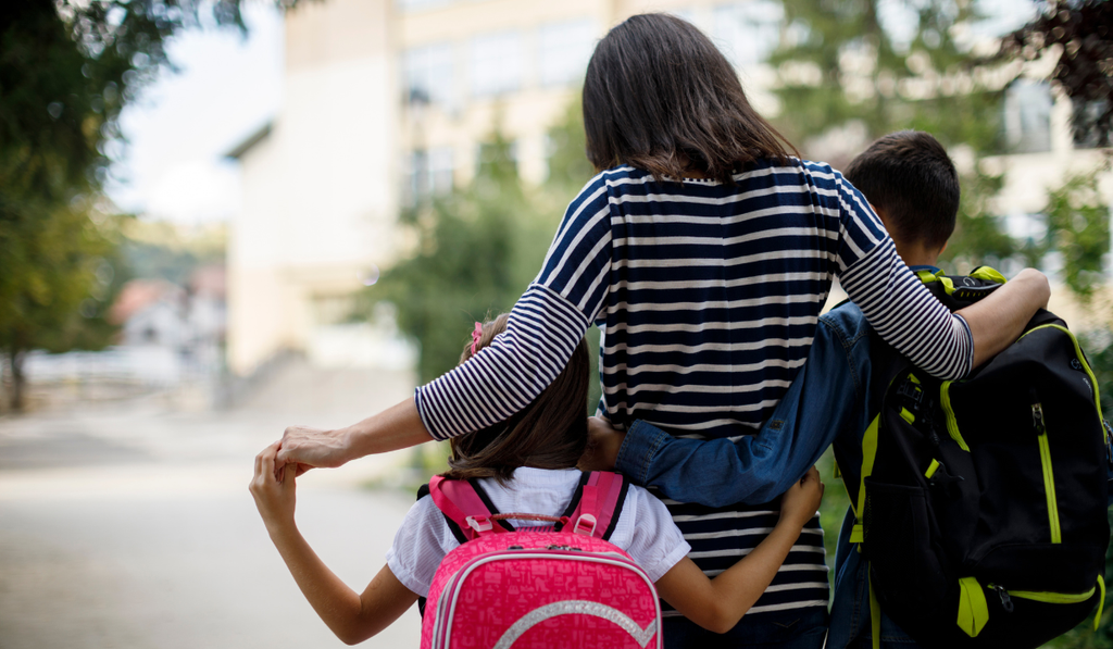 Parent walking with kids to school.